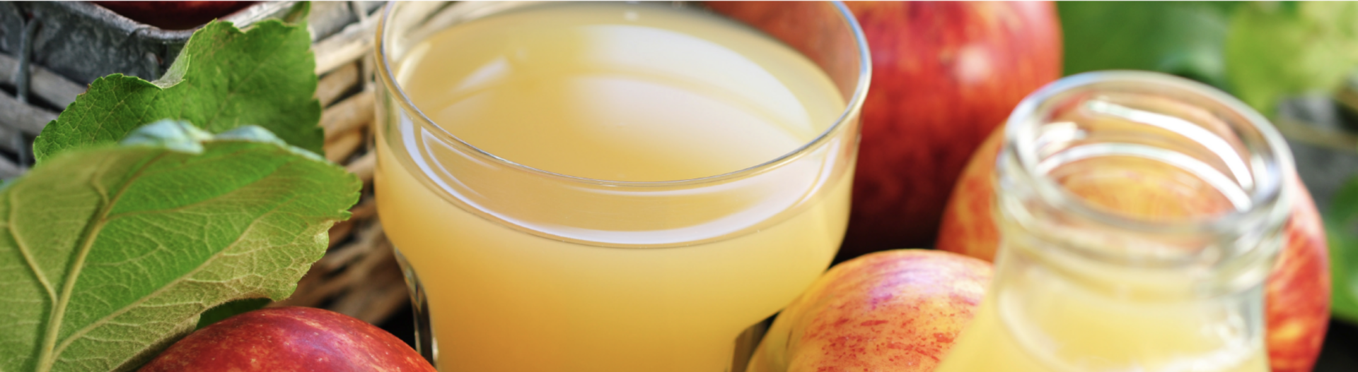 HÃ¶llinger naturtrÃ¼ber Apfelsaft im Glas neben einem Korb